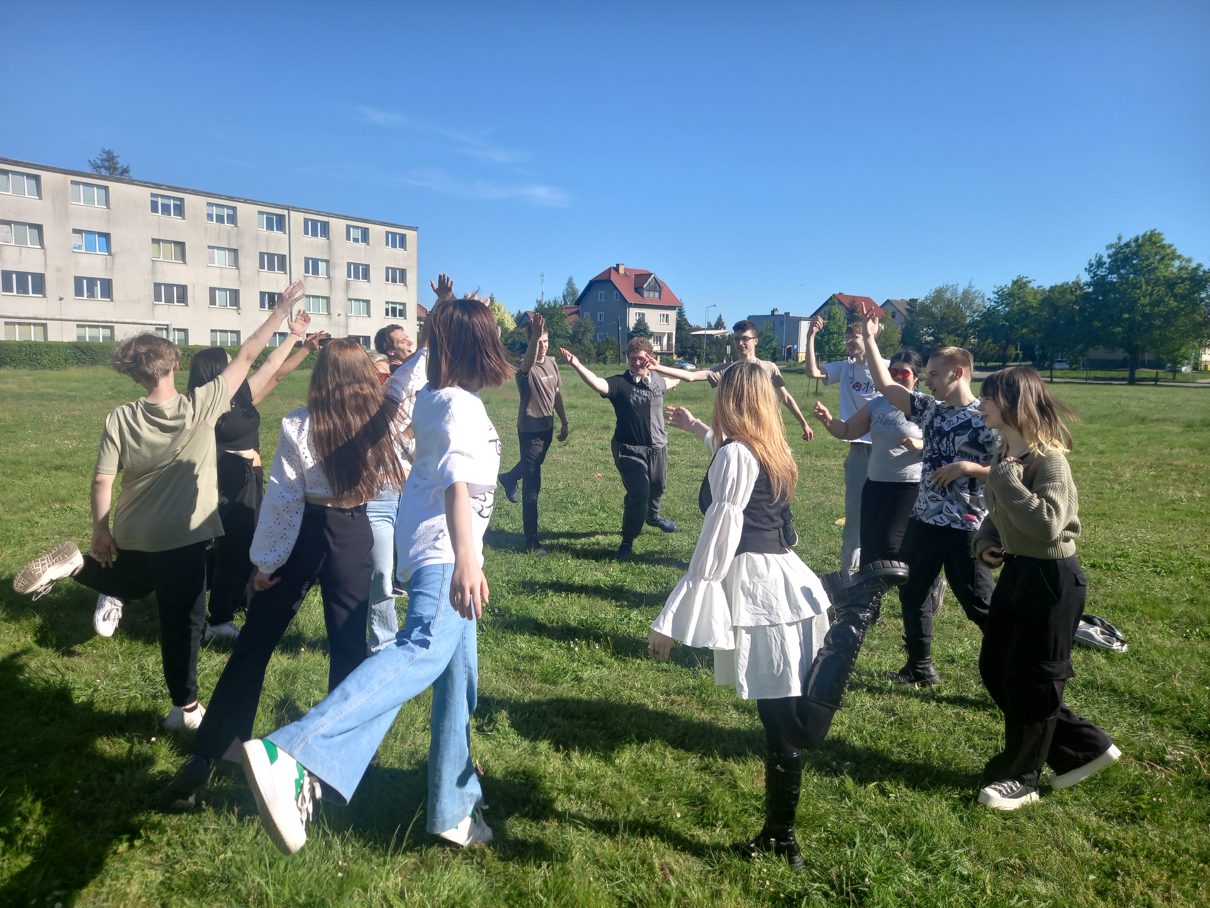 Grupa młodzieży tańczy w okregu