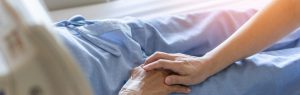 Starsza osoba na łóżku szpitalnym pod opieką personelu medycznego