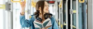 Kobieta podróżująca komunikacją miejską trzymająca książkę