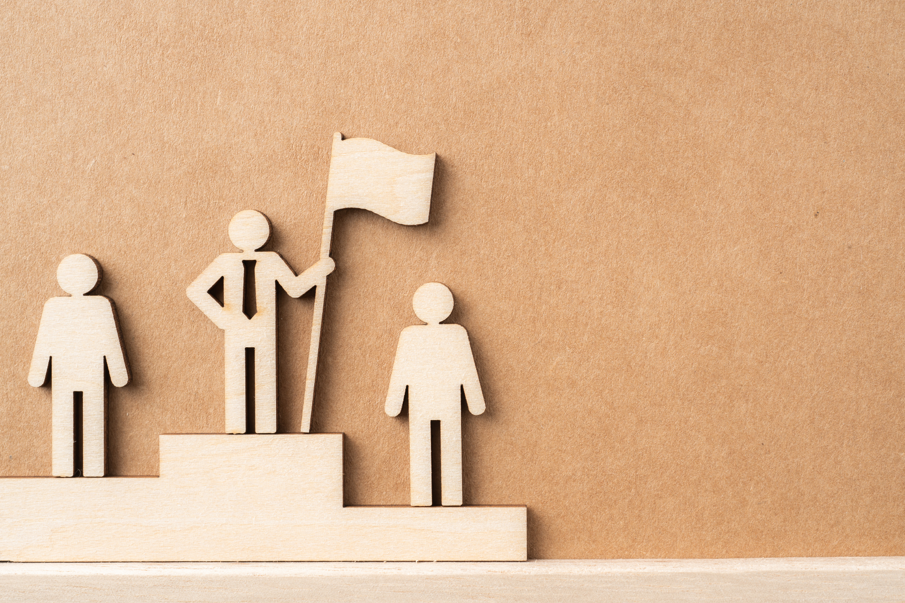 Grafika 3 drewniane postacie na podium